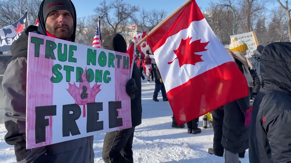 protesters holding sign, canadian flag