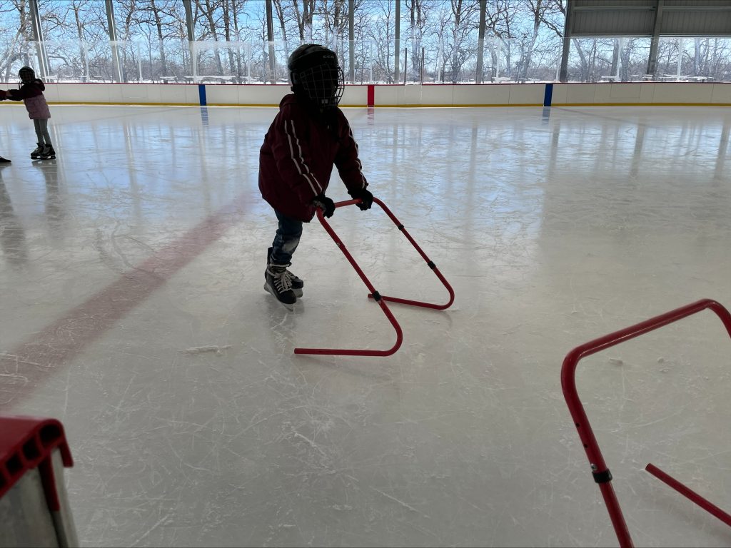 child learning to skate on rink