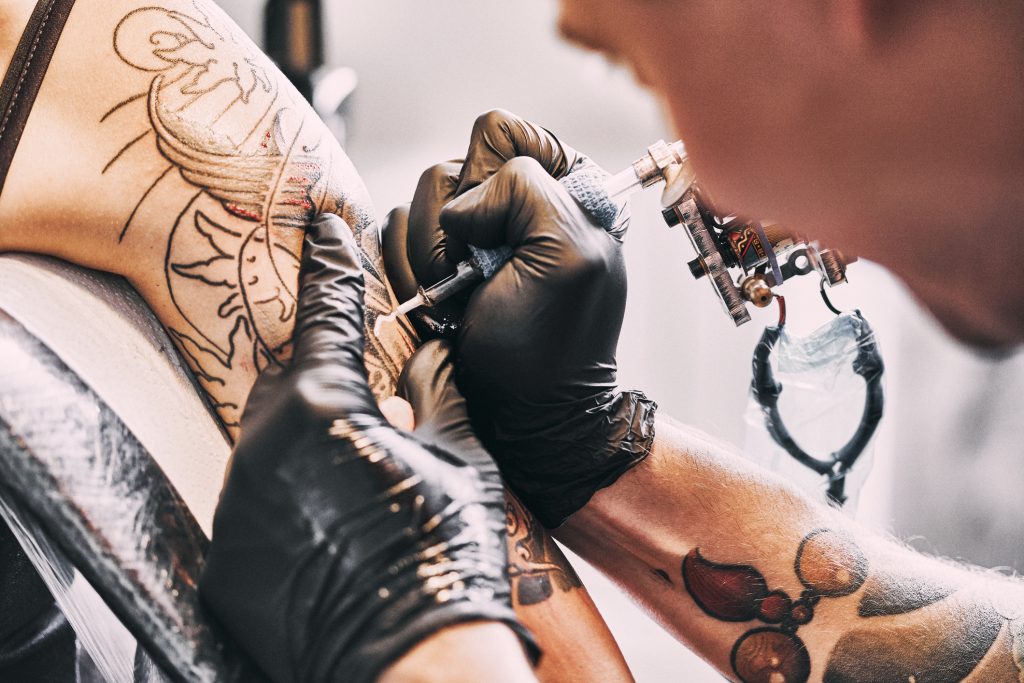 tattoo artist tattooing someone's arm